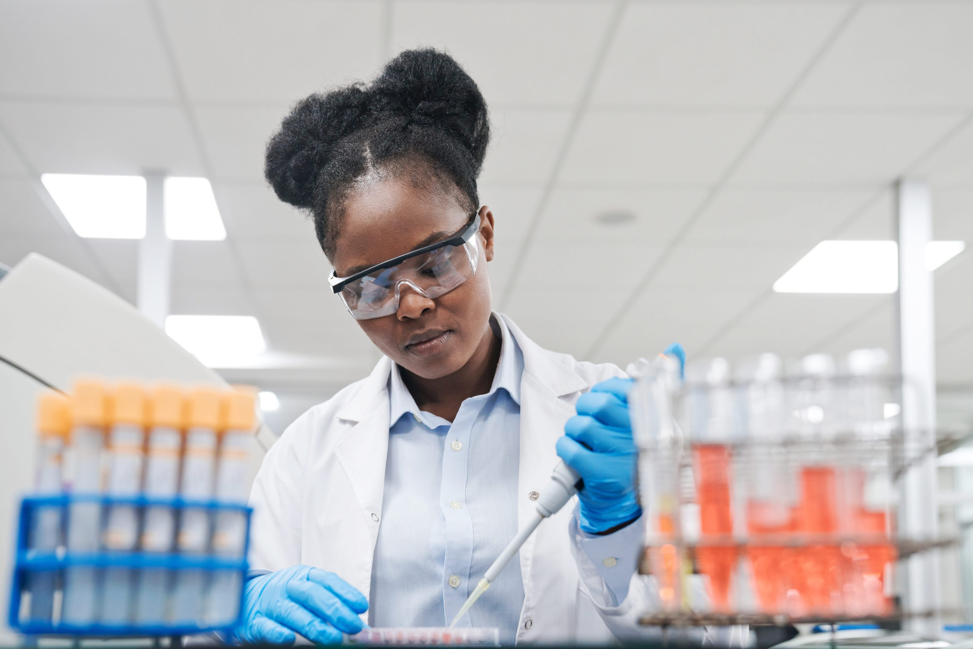 A doctor wearing safety glasses while working with blood samples. 