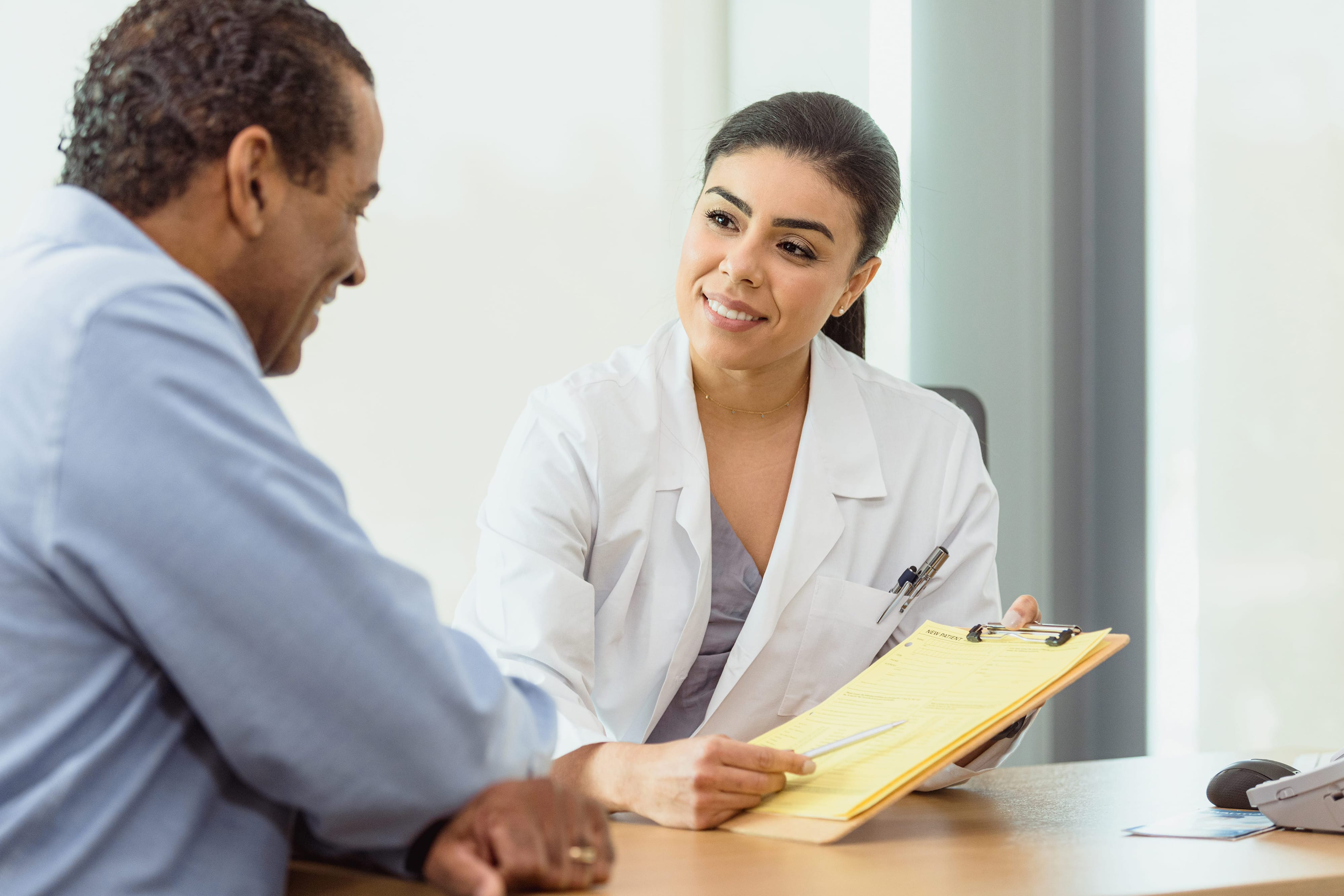 A doctor showing a medical form to a patient. 