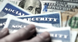 Social security cards, fingers, a $100 bill